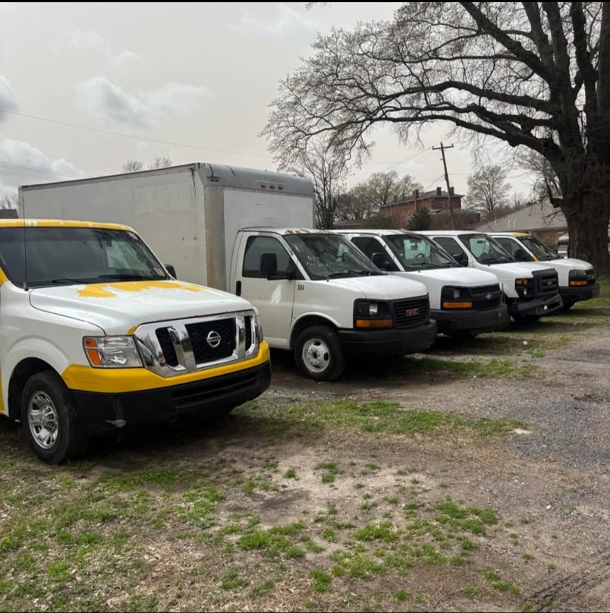 Overflow Masters cargo vans and a box truck parked in a row at the Memphis yard